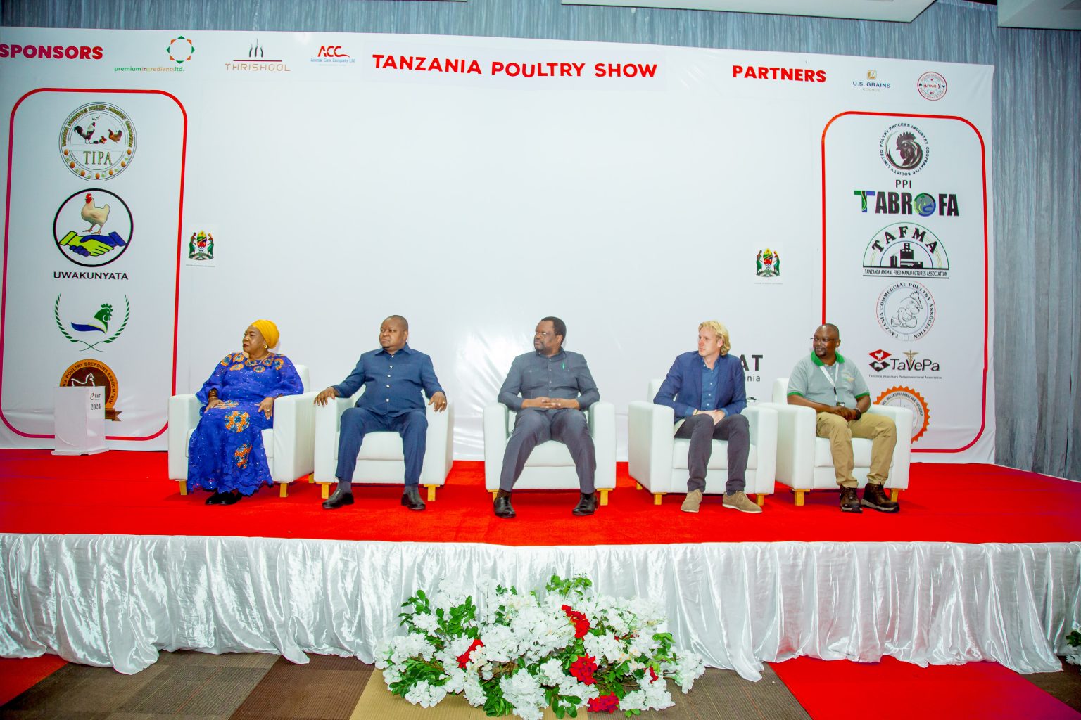 A panel of five speakers seated on stage at the Tanzania Poultry Show.